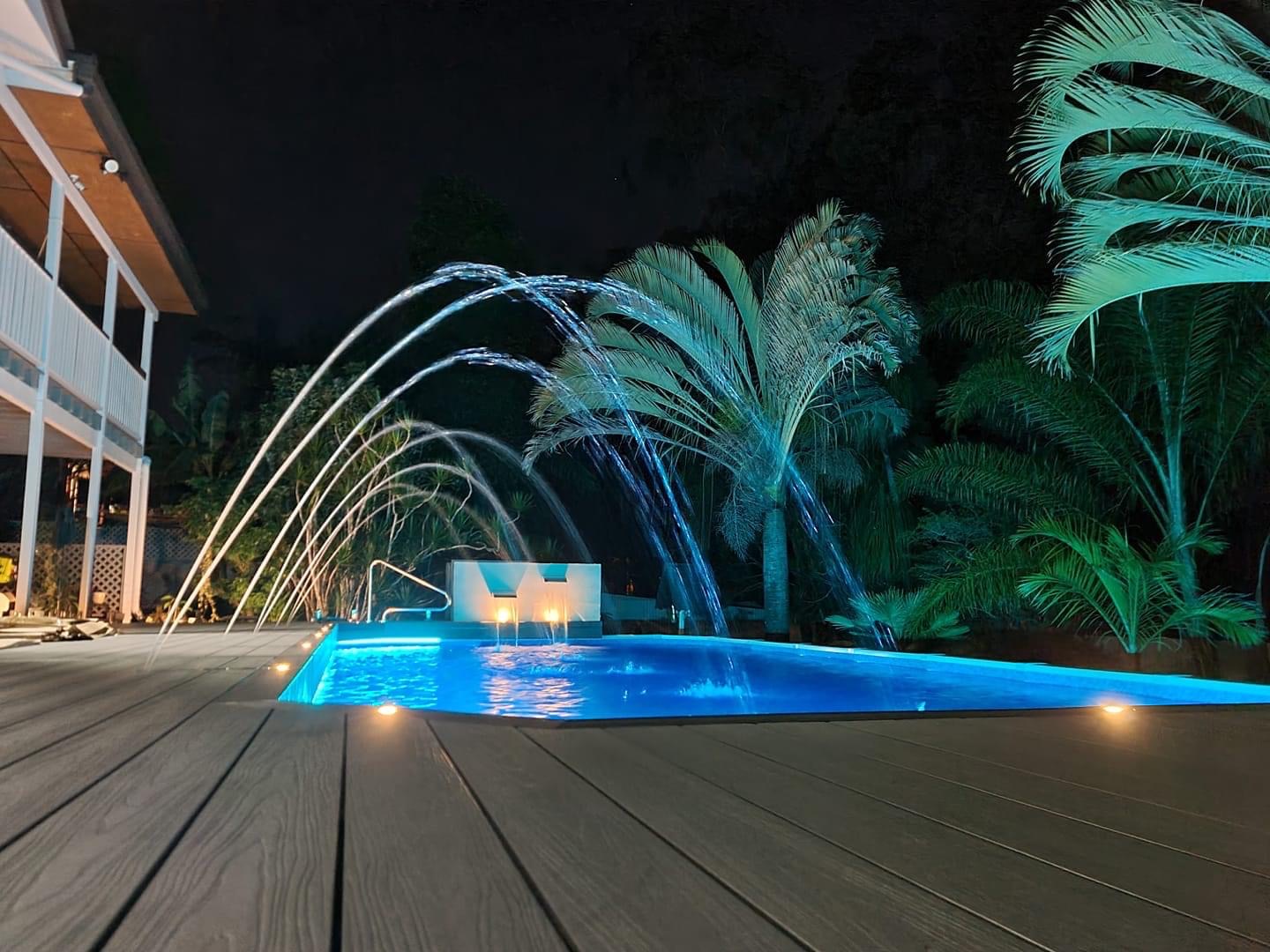 Night view of inground pool with water foundation and beautiful lighting
